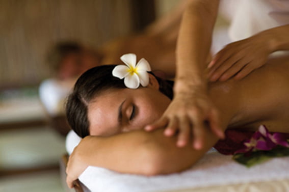 A young woman having massage in tropical spa